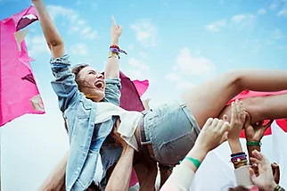 A young girl in recovery crowd surfs and is having fun without drugs.